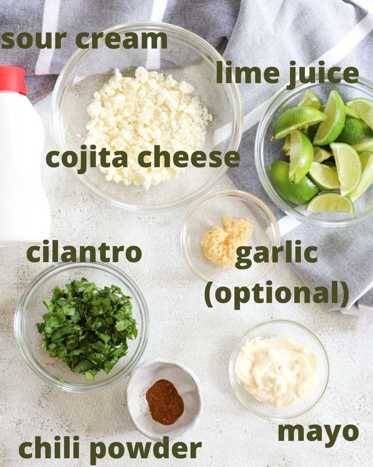 Mexican elote (street corn) ingredients on a table with a tablecloth