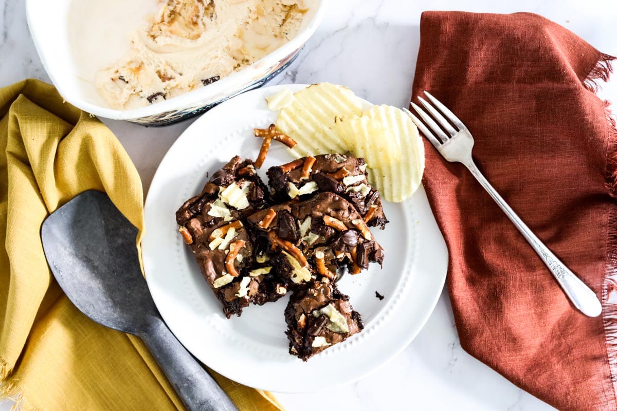 ice cream with brownies and ice cream scoop on orange napkin