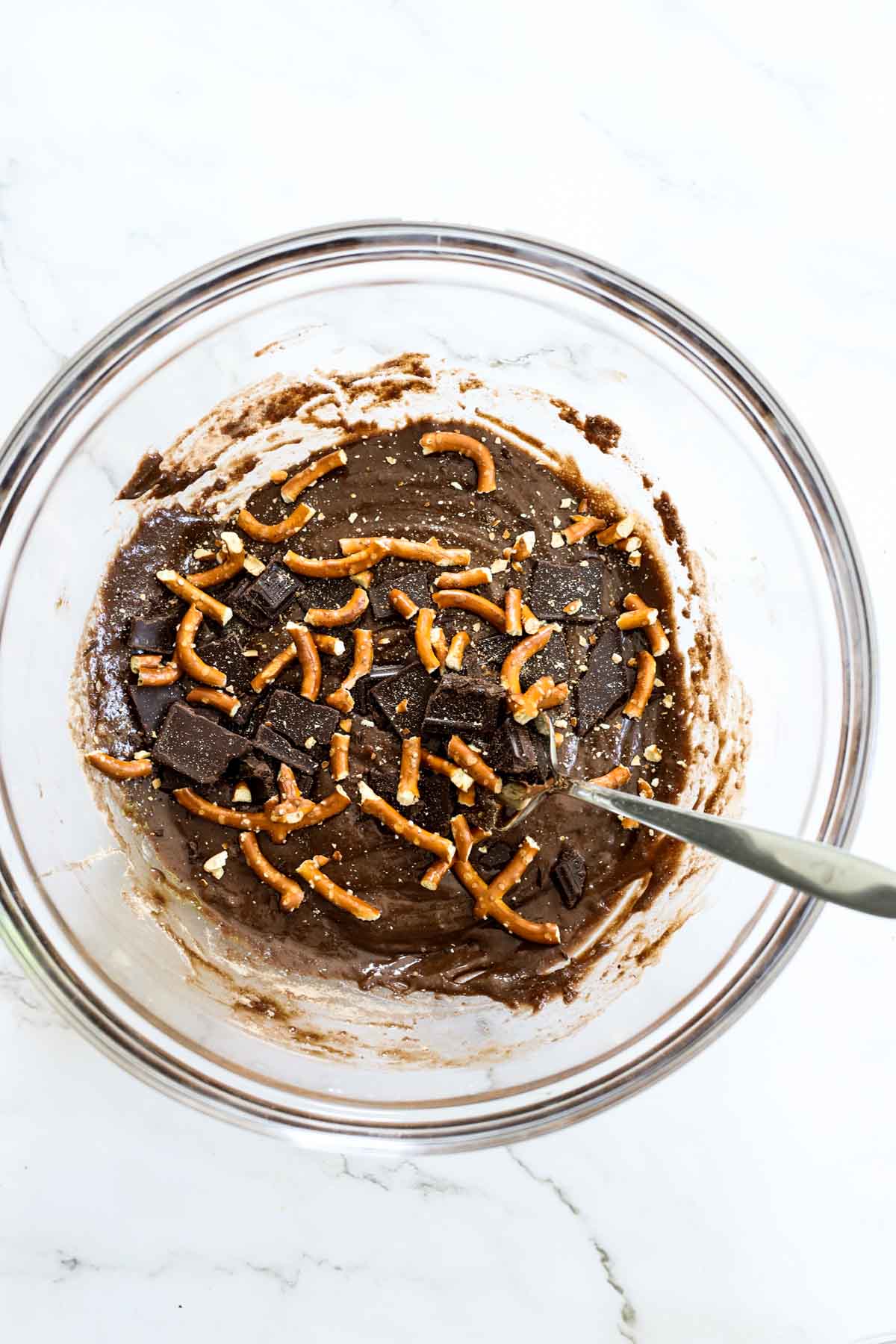 brownie batter with pretzel bits in a mixing bowl