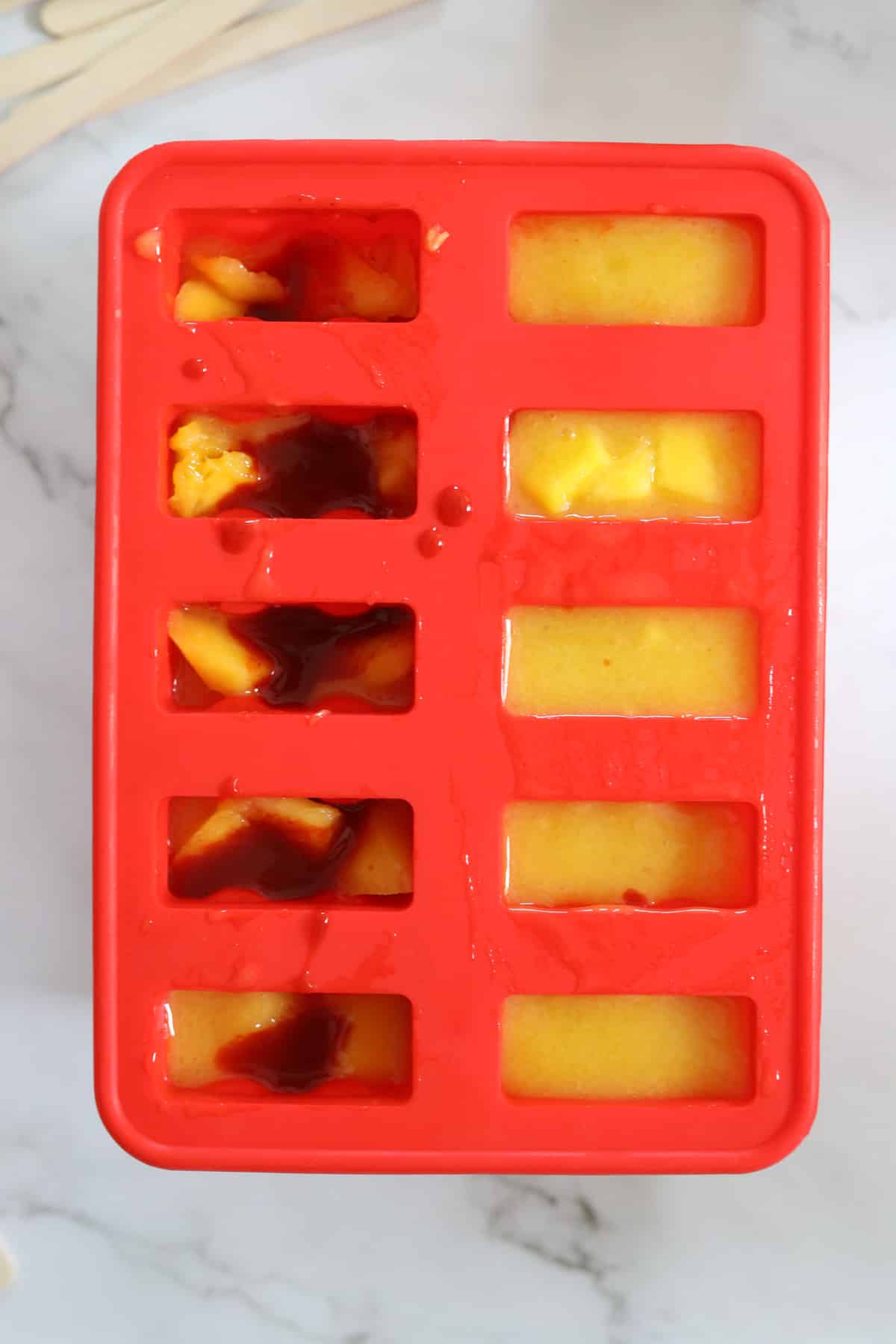 popsicle molds with mango puree and chamoy
