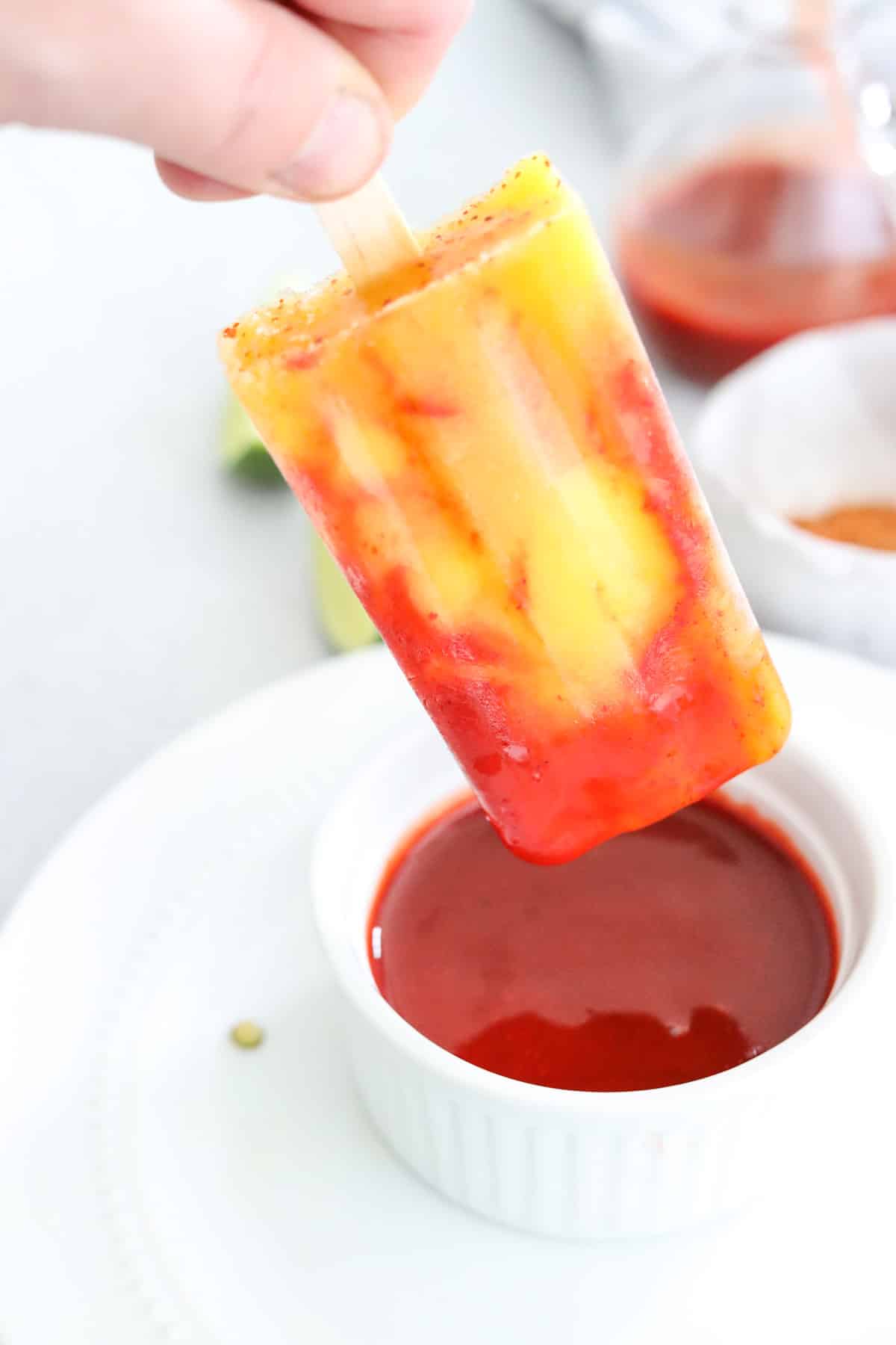dipping a popsicle into chamoy