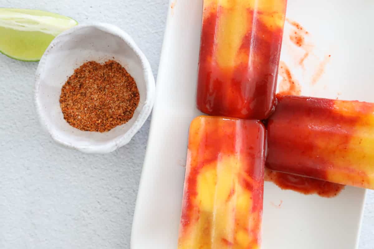 serving mangonada popsicles with tajin