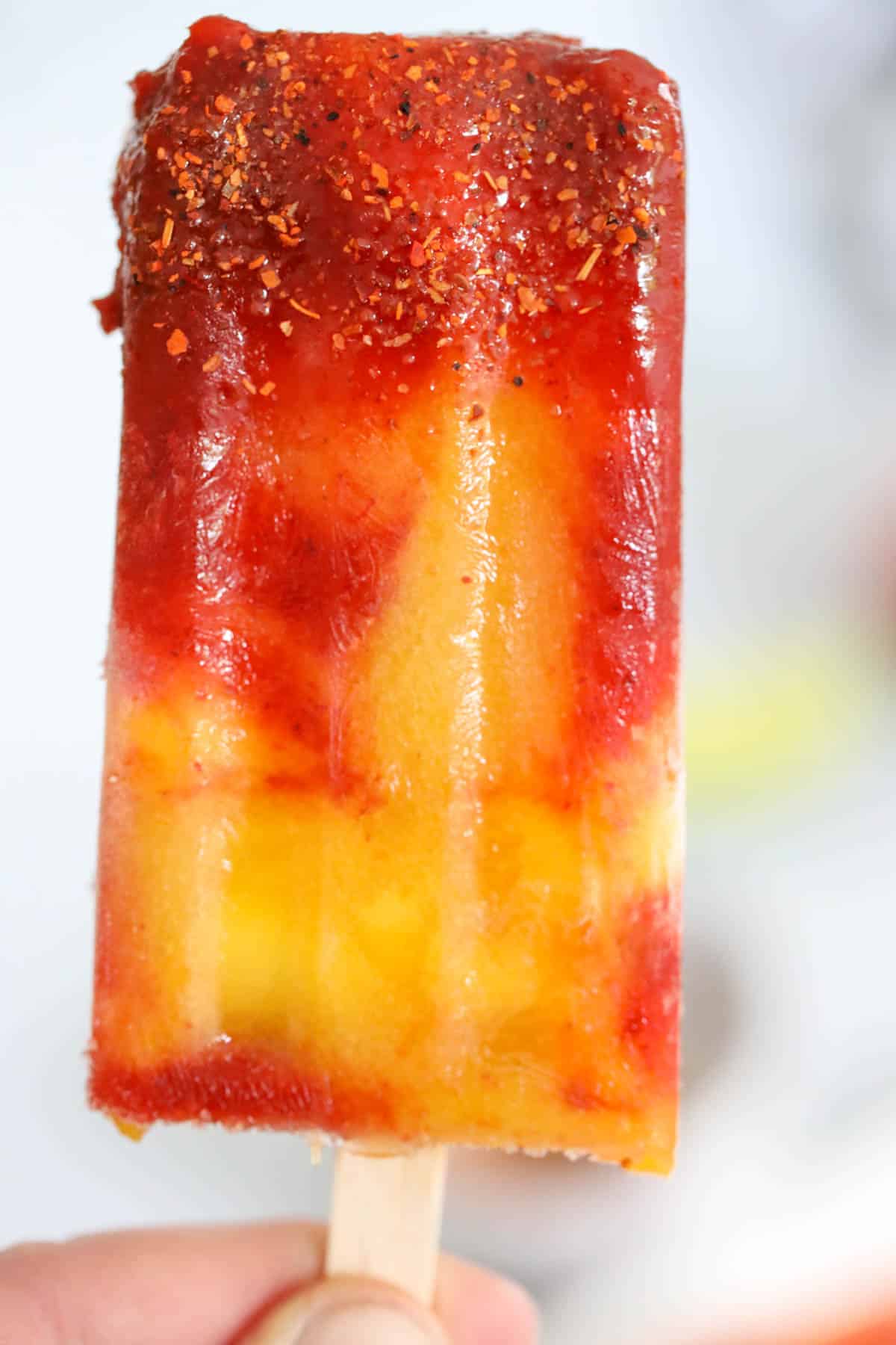 mangonada popsicle dipped in Tajin sauce and chamoy