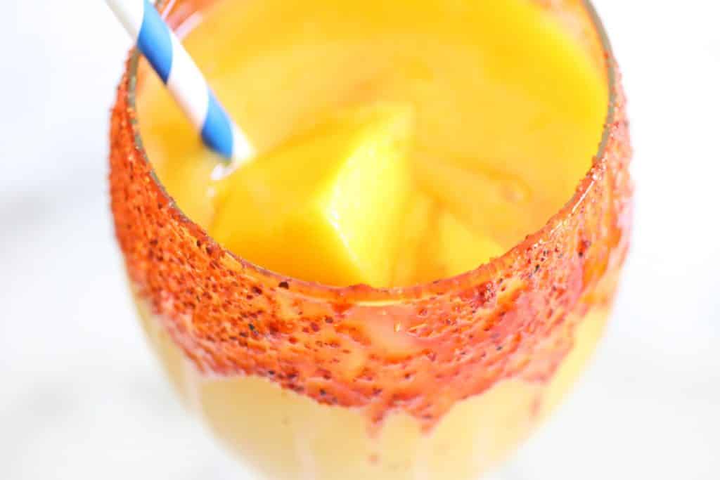 looking inside the glass of a blended mango smoothie