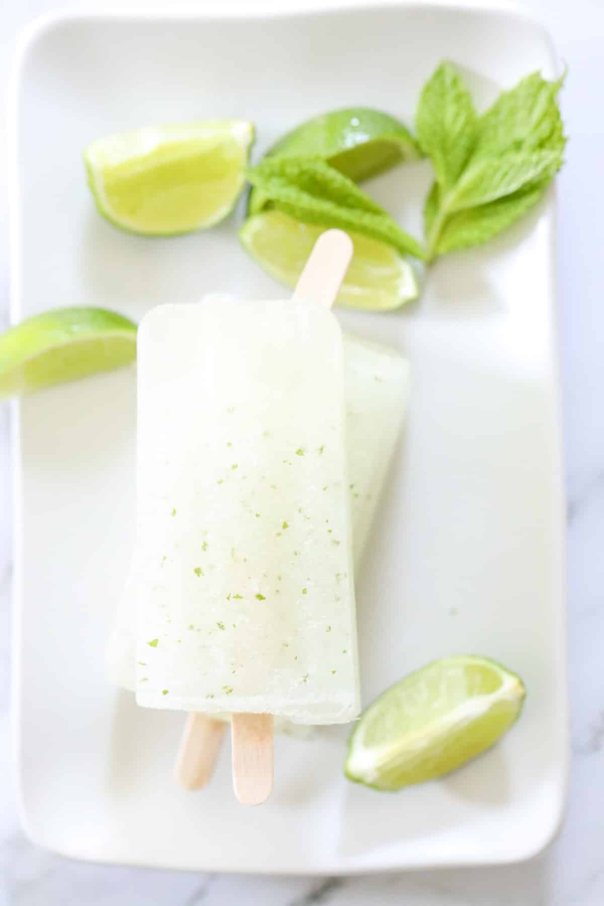 mojito popsicles with lime wedges and mint leaves