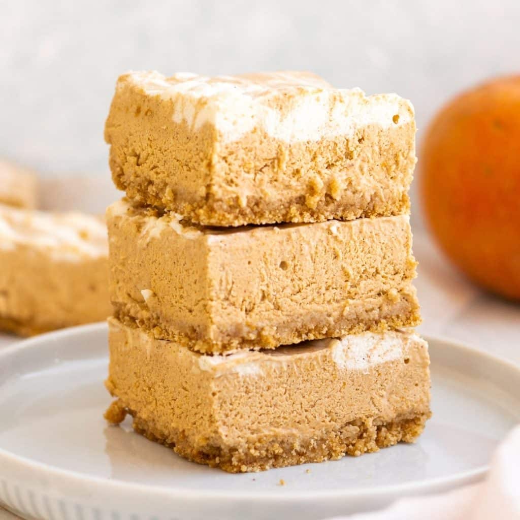 no bake pumpkin cheesecake bars stacked in a set of three