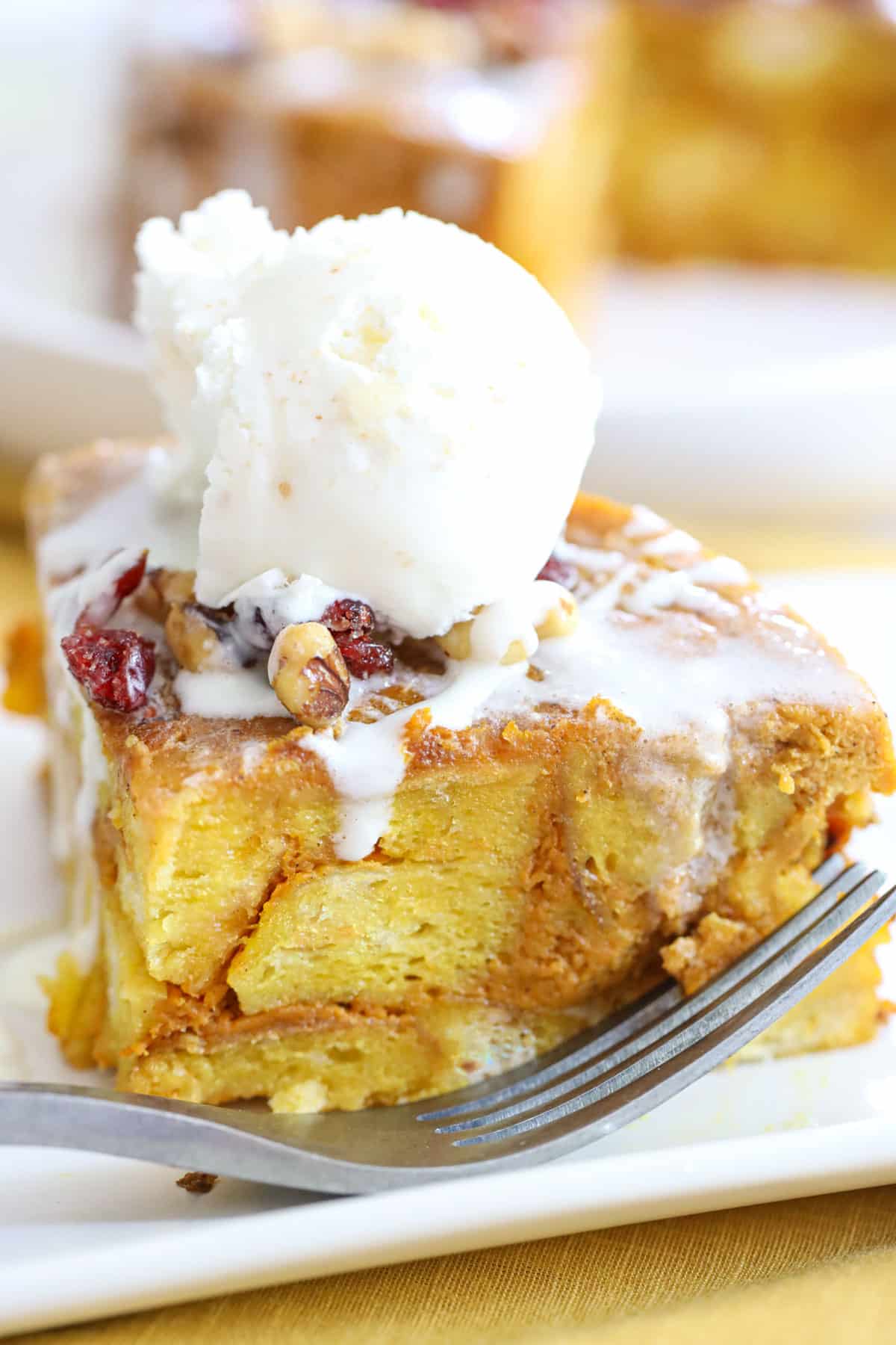 slice of pumpkin bread pudding with a scoop of vanilla ice cream on top