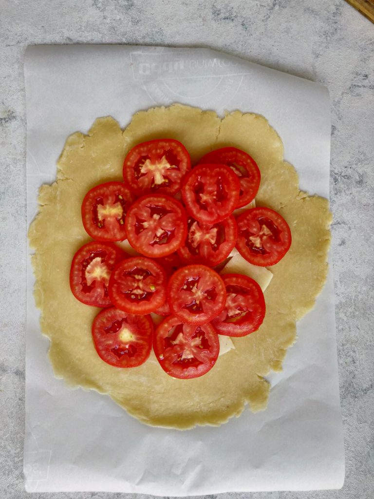 adding tomatoes to crust