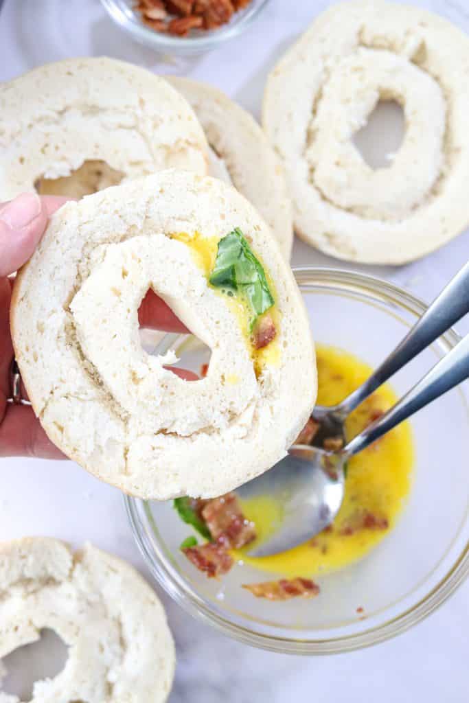 adding egg mixture to inside of bagel opening