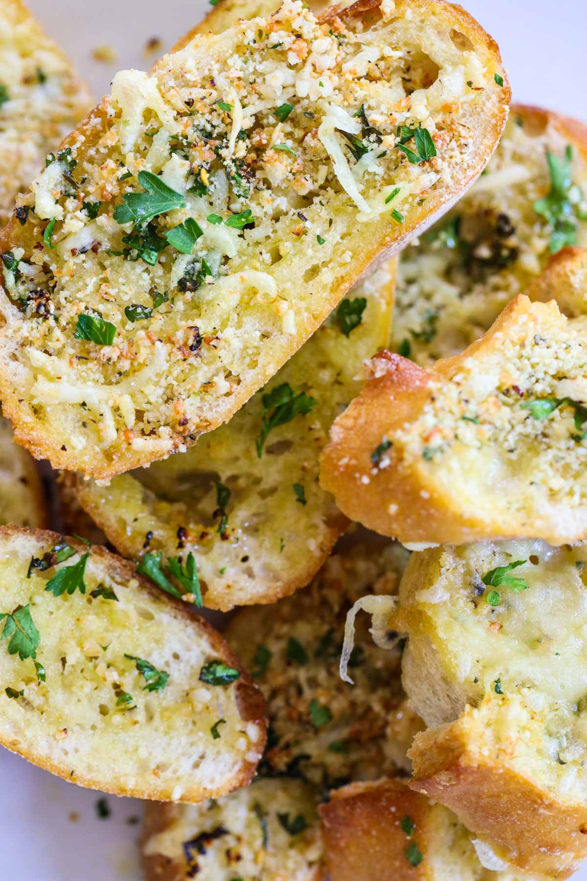 garlic bread slices stacked on top of one another with parsley on top