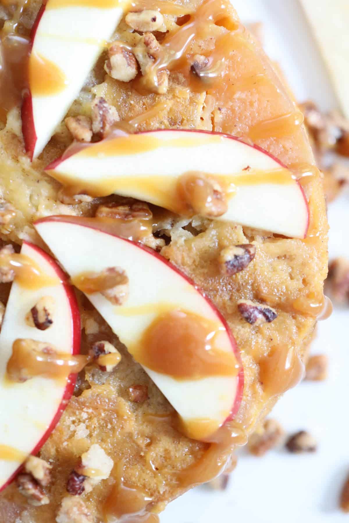 apple bread pudding with thin apple slices and caramelized nuts with caramel drizzle