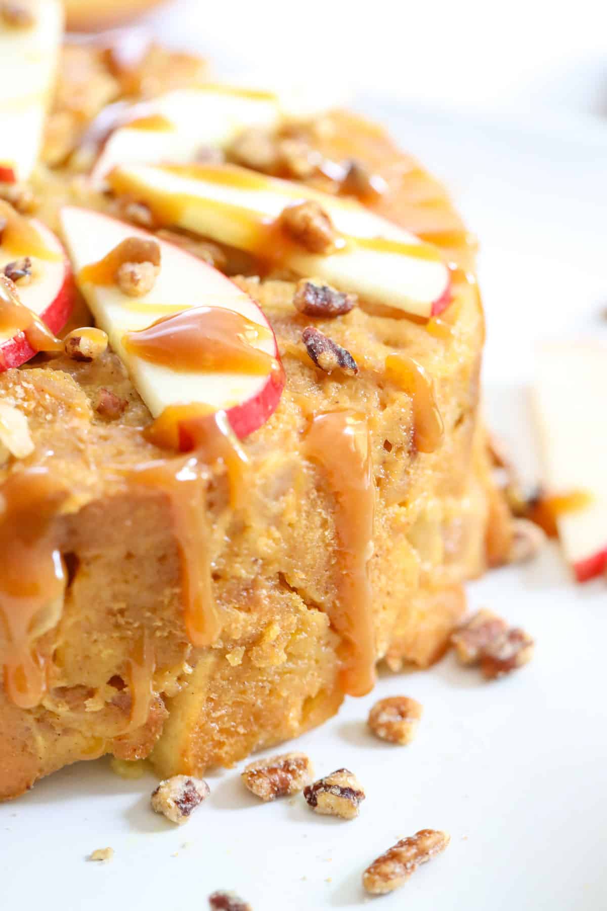 caramel sauce dripping down the side of apple bread pudding