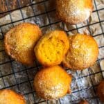 pumpkin fritters on a drying rack with a cinnamon stick