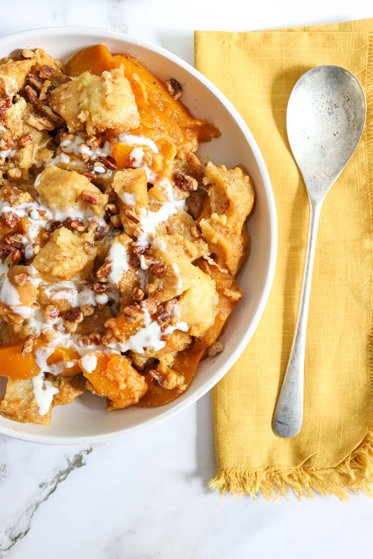 bread pudding in a dish with a spoon and cloth napkin