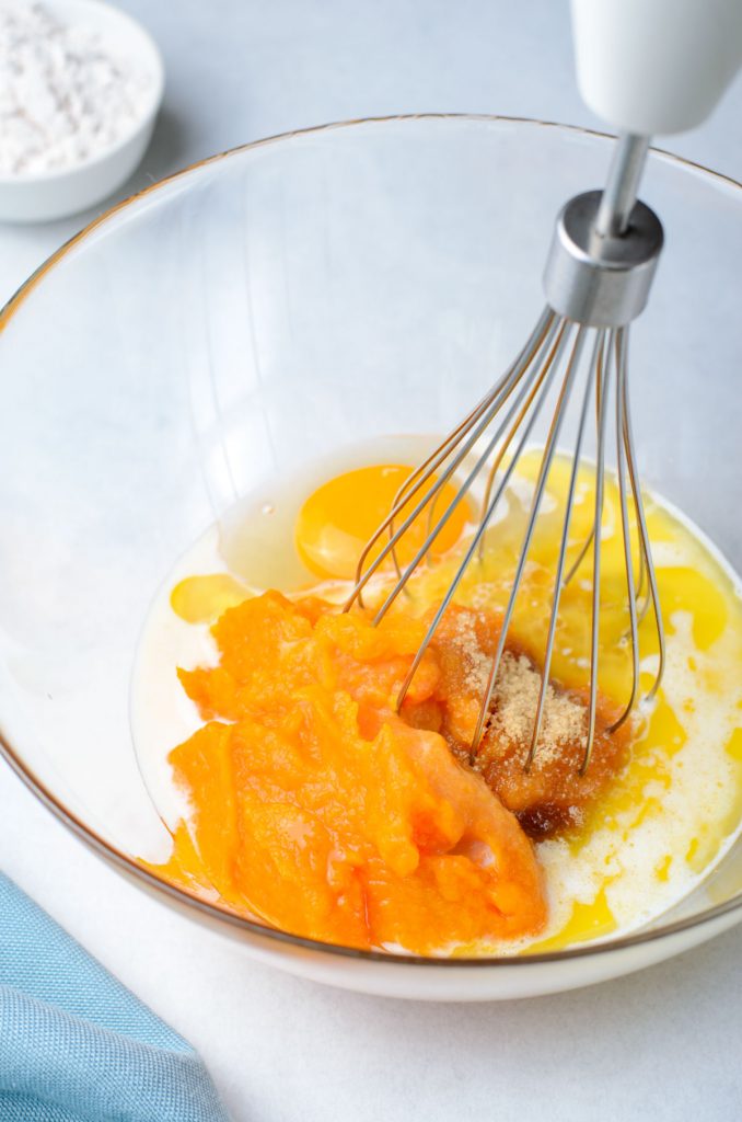 wet ingredients in a bowl, including pumpkin puree, sugar, and egg