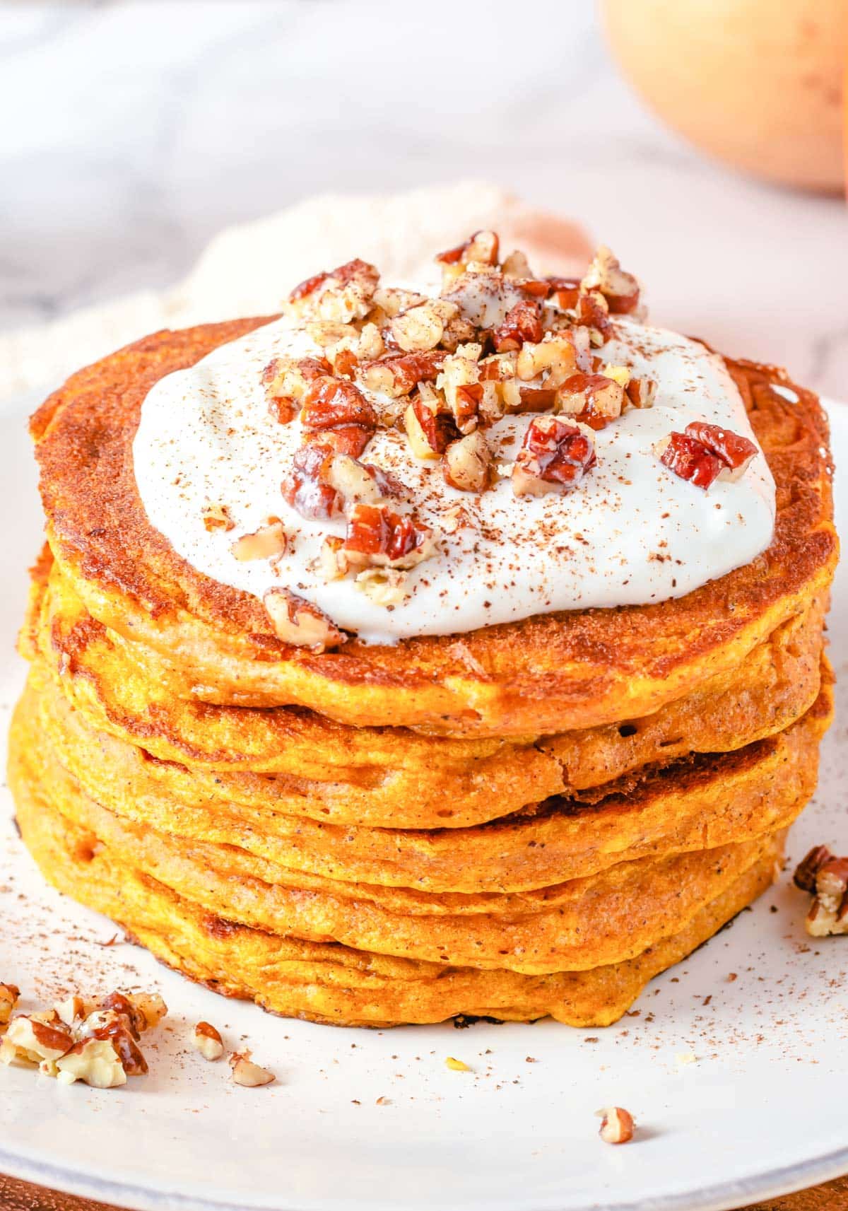 frosted pumpkin pancakes with crushed nuts on top