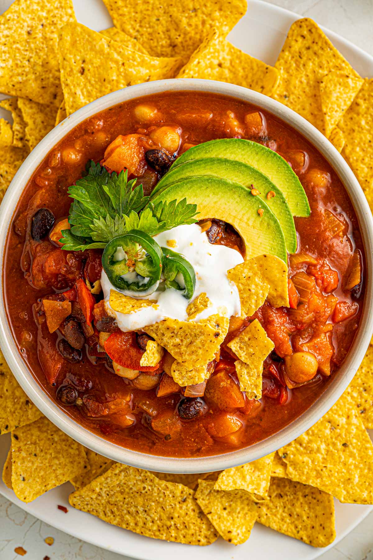 view of chili from above with toppings such as sour cream, avocado, and cilantro