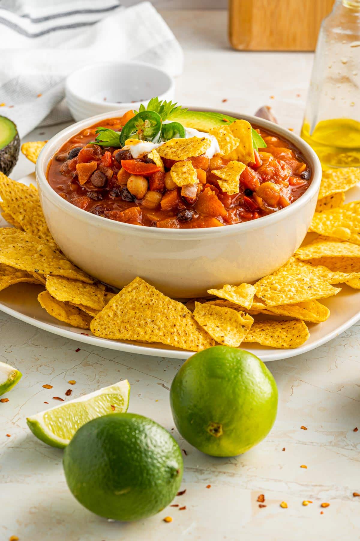 bowl of chili with limes slices and golden tortilla chips