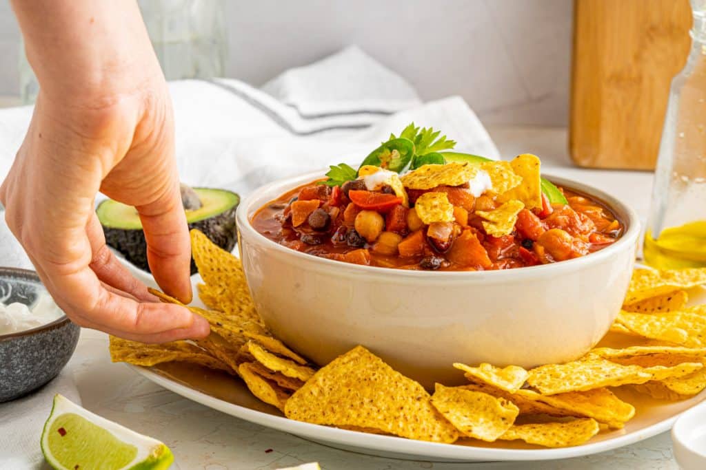 grabbing a chip for dipping in chili beans