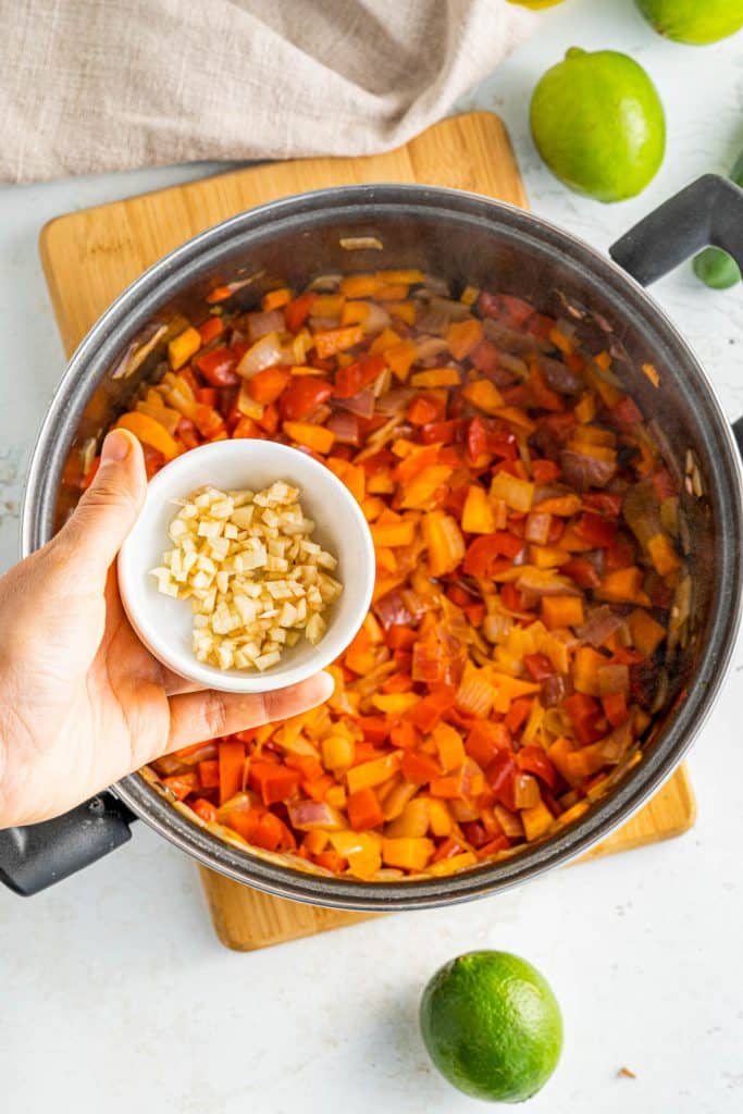 adding garlic to large pot