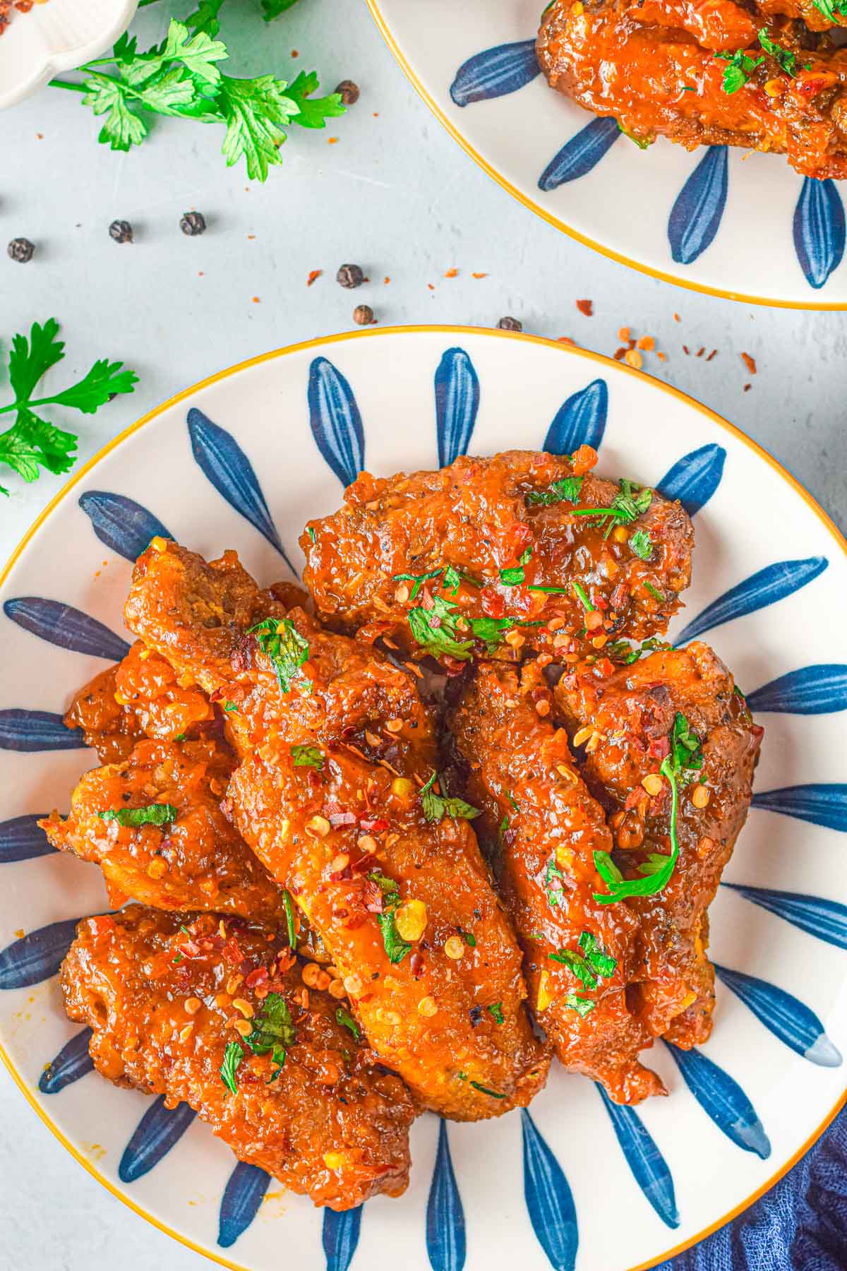 bowl of sweet thai chili chicken wings with red pepper flakes scattered about