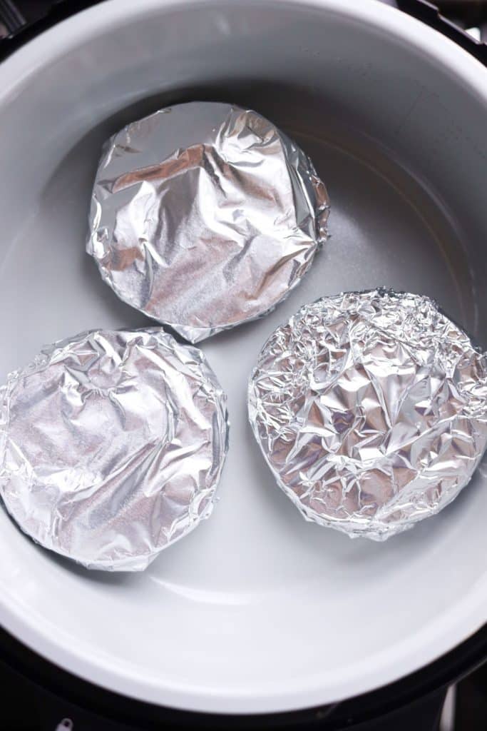 burger patties wrapped in foil in the air fryer
