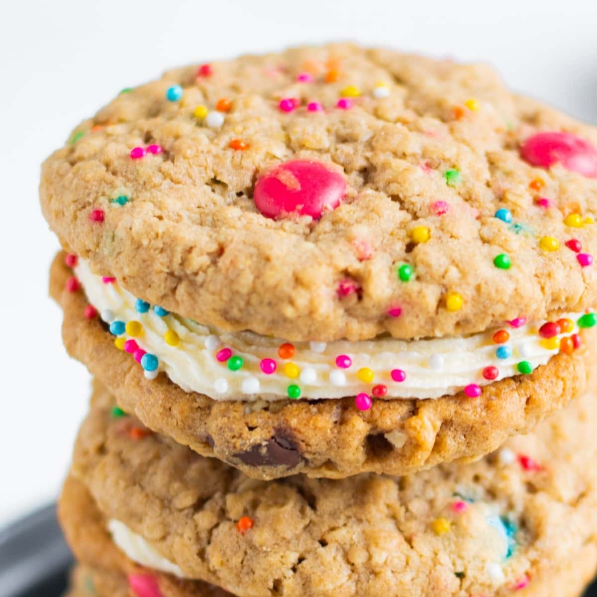 oatmeal m&m whoopie pie cookies with bright pink and blue sprinkles sandwiched with cream cheese filling