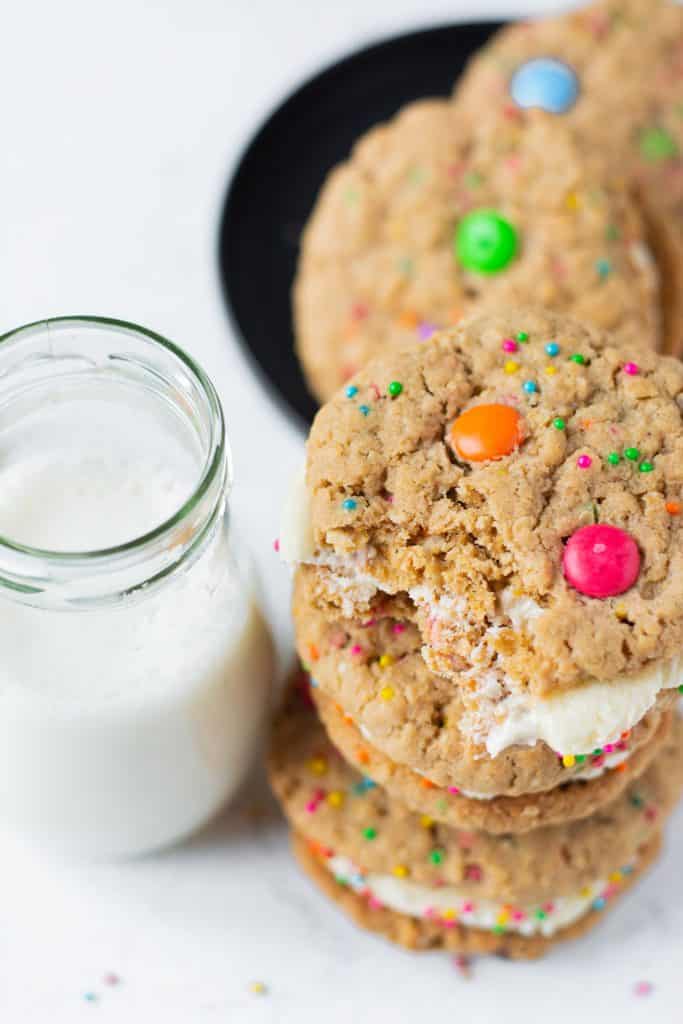 full glass of milk with monster cookie sandwiches