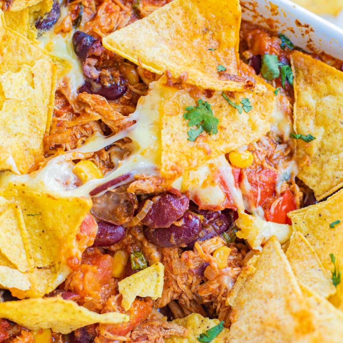 cheesy Doritos with chicken, beans, cilantro and tomatoes