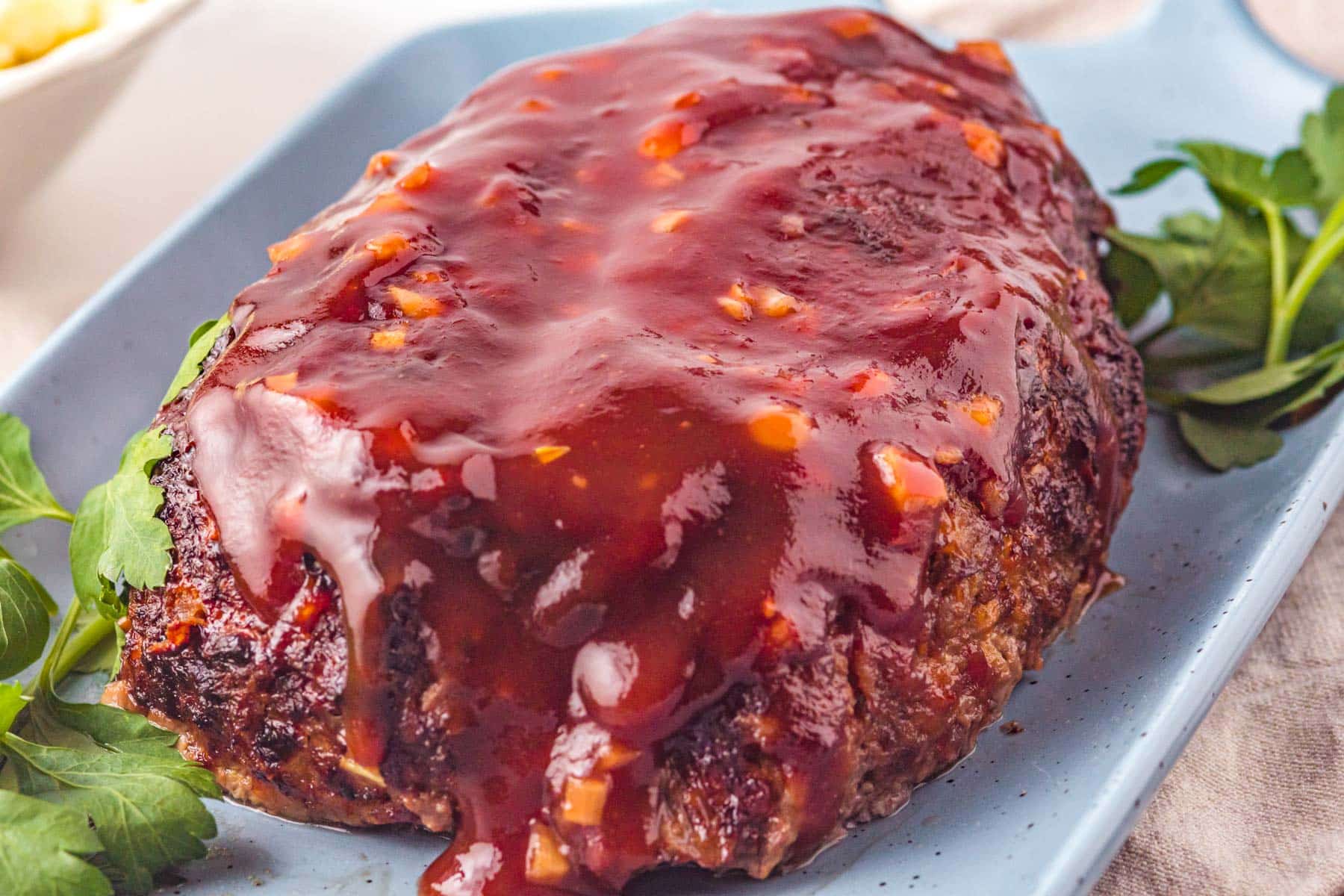 whole meatloaf smothered in delicious sweet dijon sauce on a blue plate
