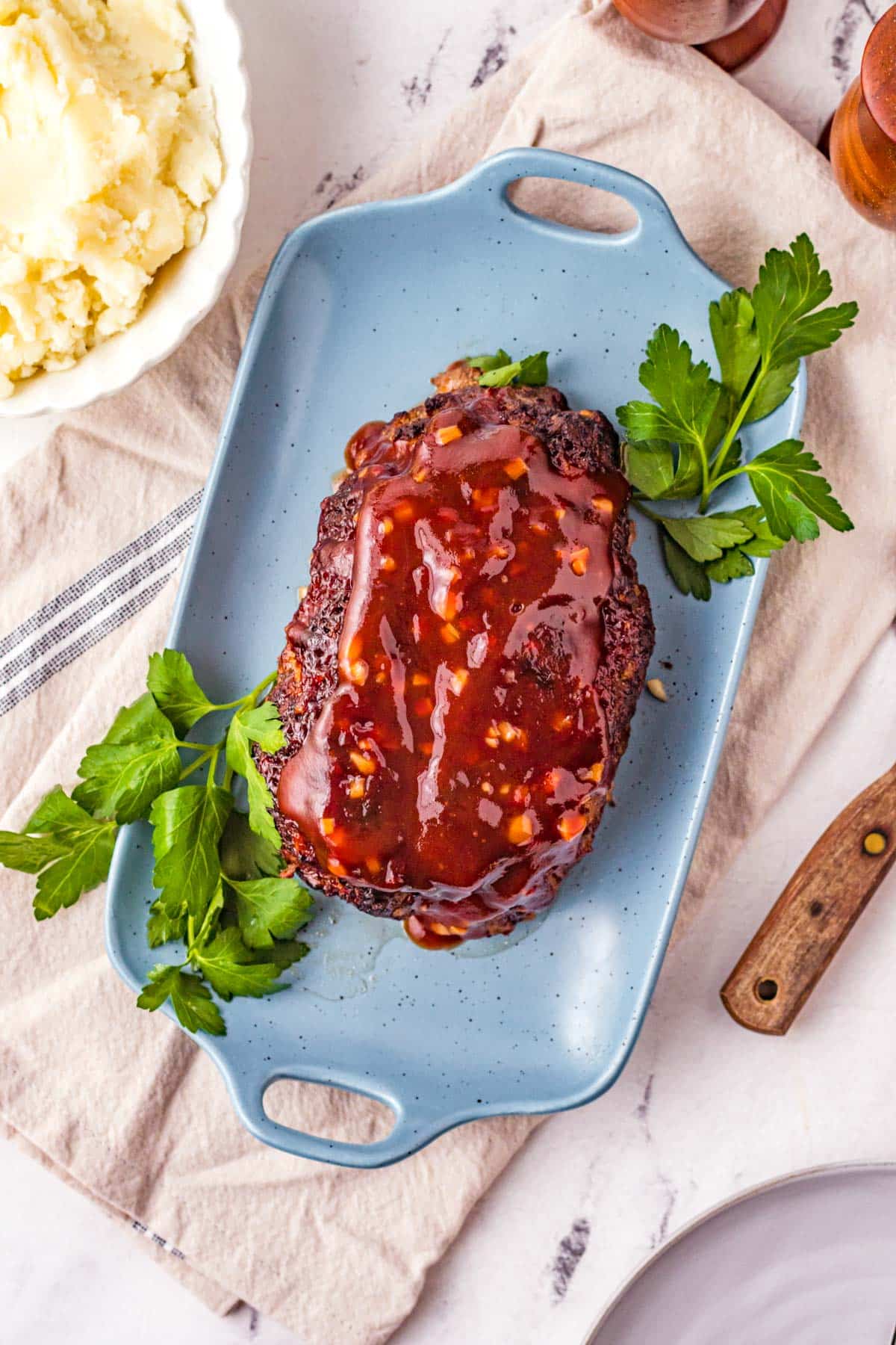 view of meatloaf from above a table with garnish and mashed potatoes