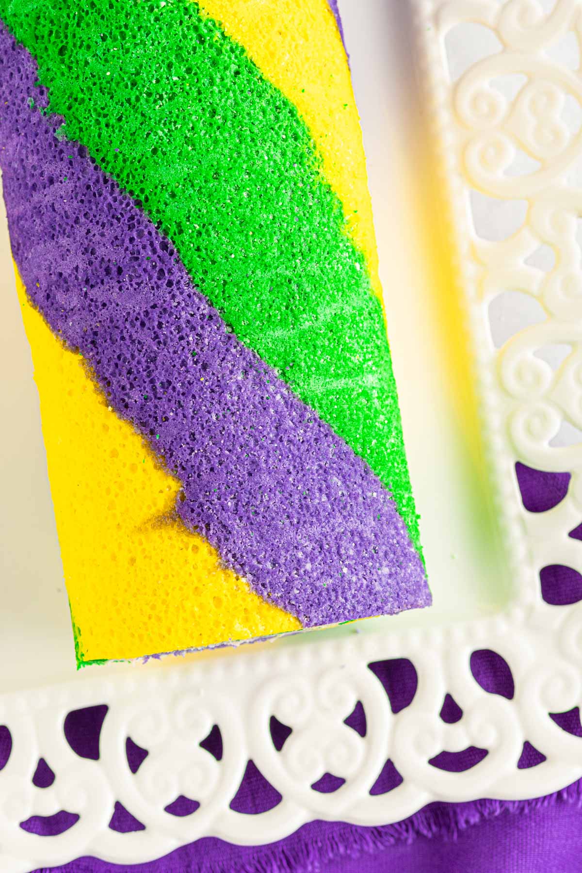 swirled king cake rolled with yellow, purple, and green