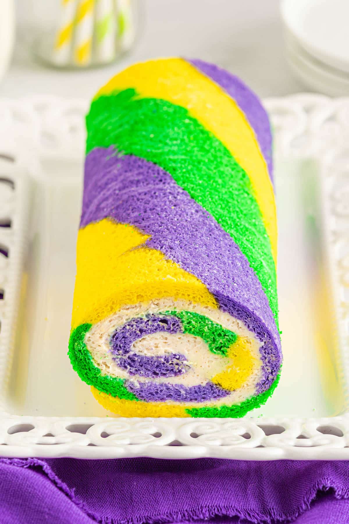 Mardi Gras rolled cake log with cinnamon cream cheese icing in the middle