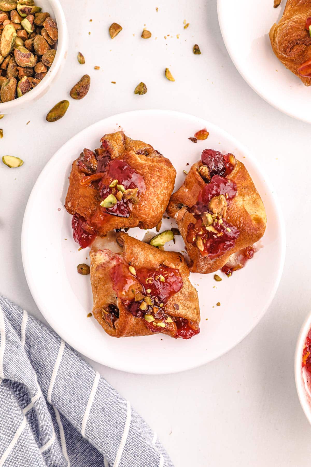 brie bites topped with pistachio nuts and cranberry sauce