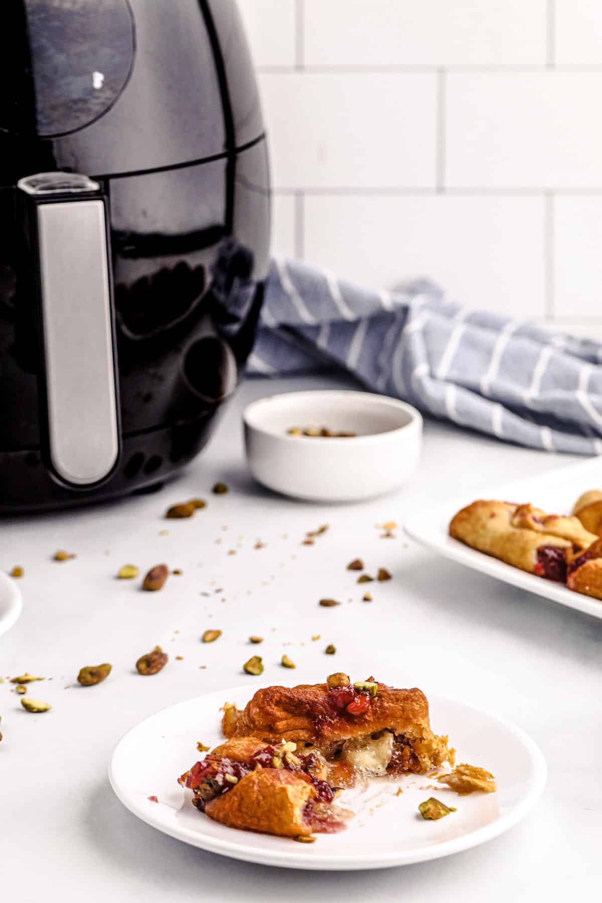 brie bites with nuts and cranberry next to an air fryer on the counter