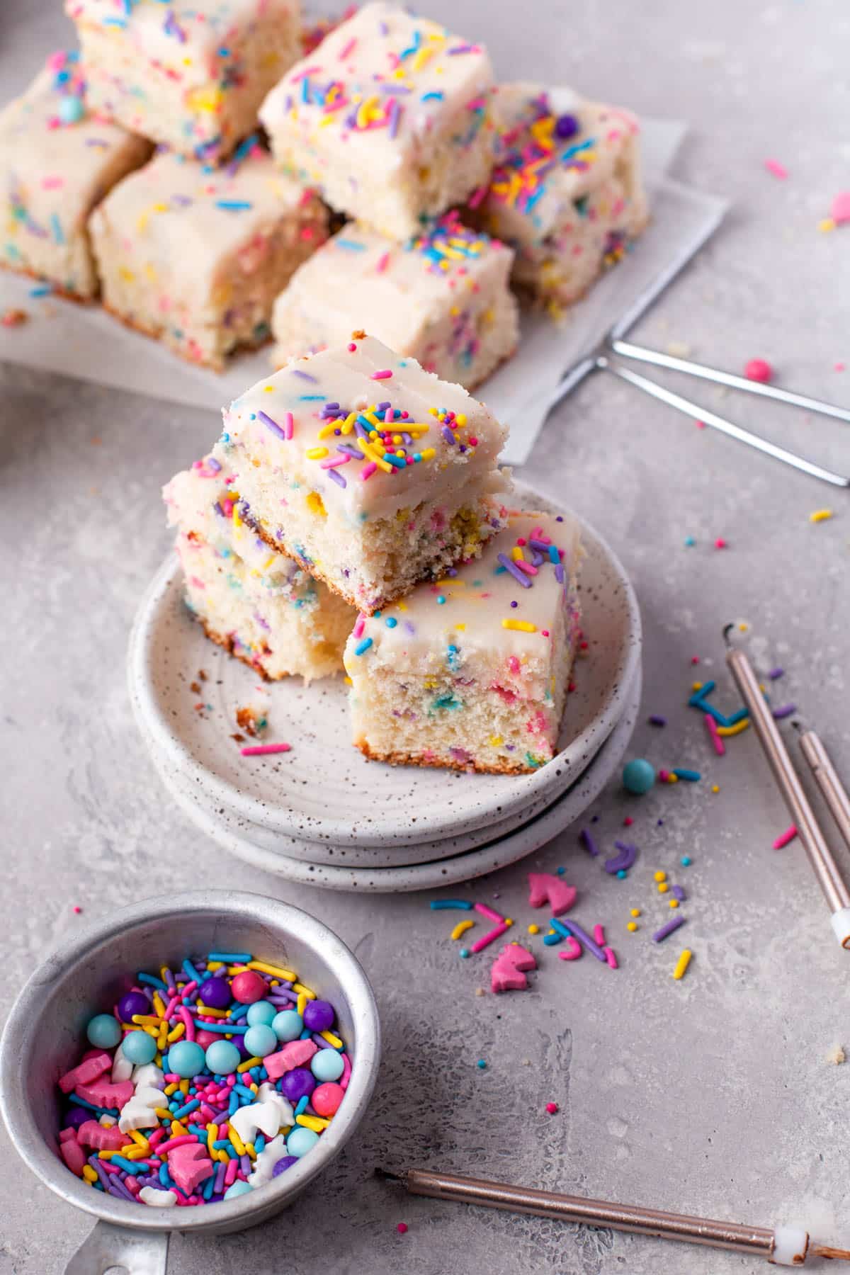 sprinkles next to sheet cake covered with sprinkles