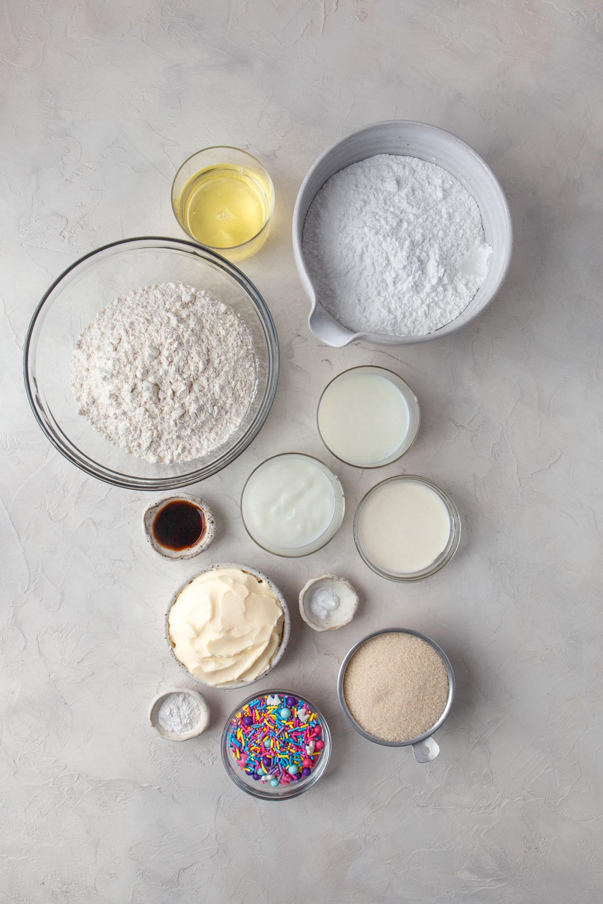 ingredients for funfetti sheet cake, including butter, flour, sprinkles, yogurt, vanilla extract