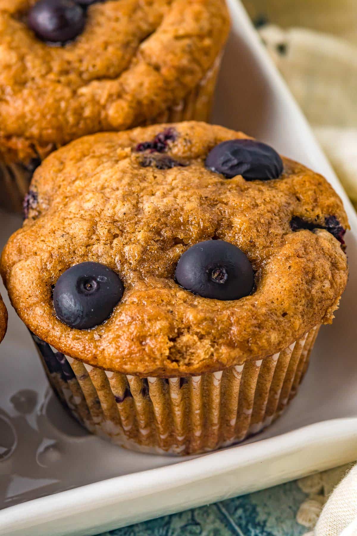muffins with blueberries on top on a white platter