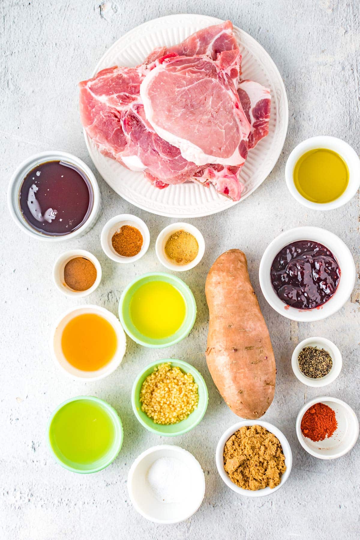 ingredients for easy glazed pork chops, including raspberry jam, lemon juice, garlic, salt, bourbon, cayenne pepper, cinnamon and paprika