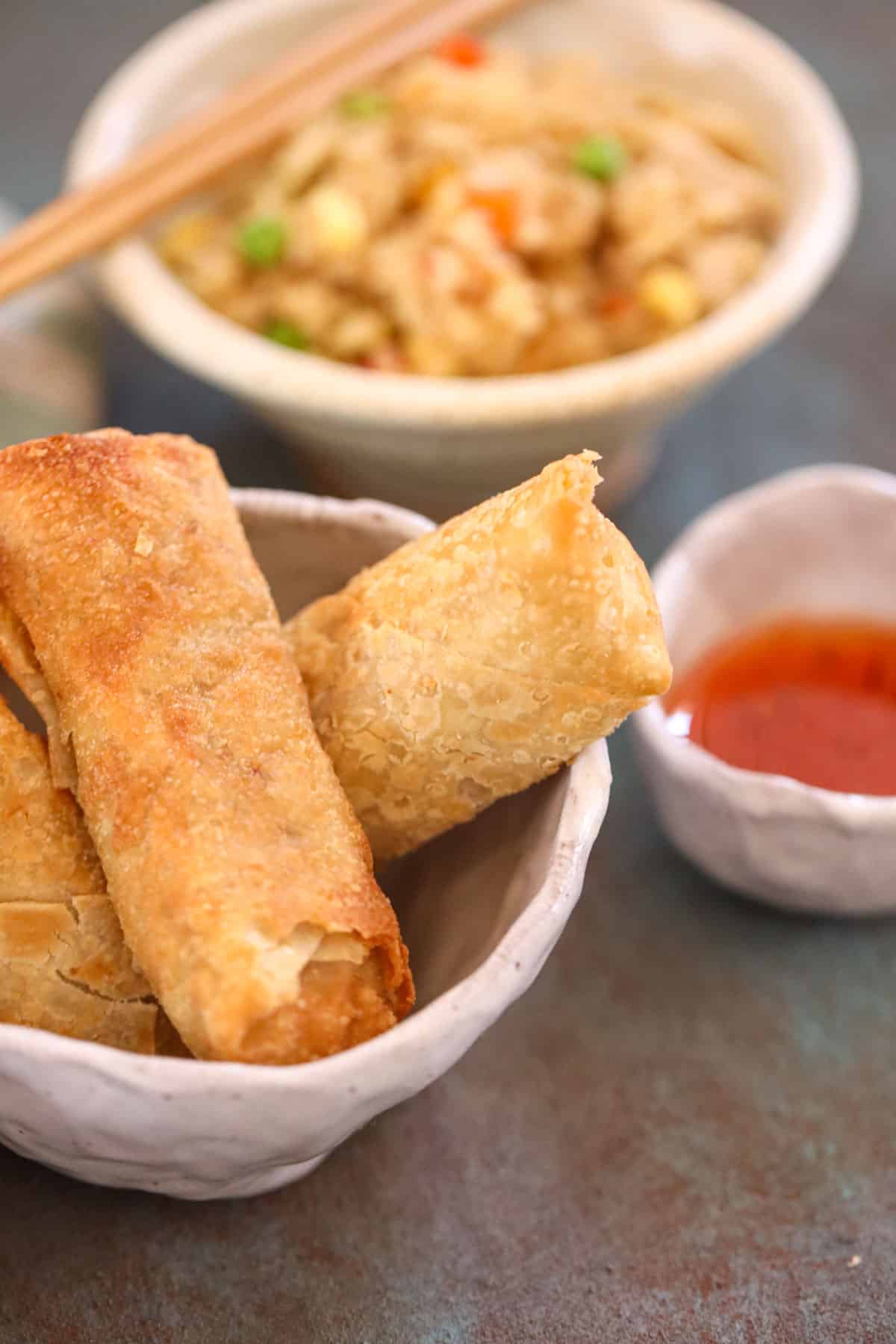 egg rolls with rice and chopsticks