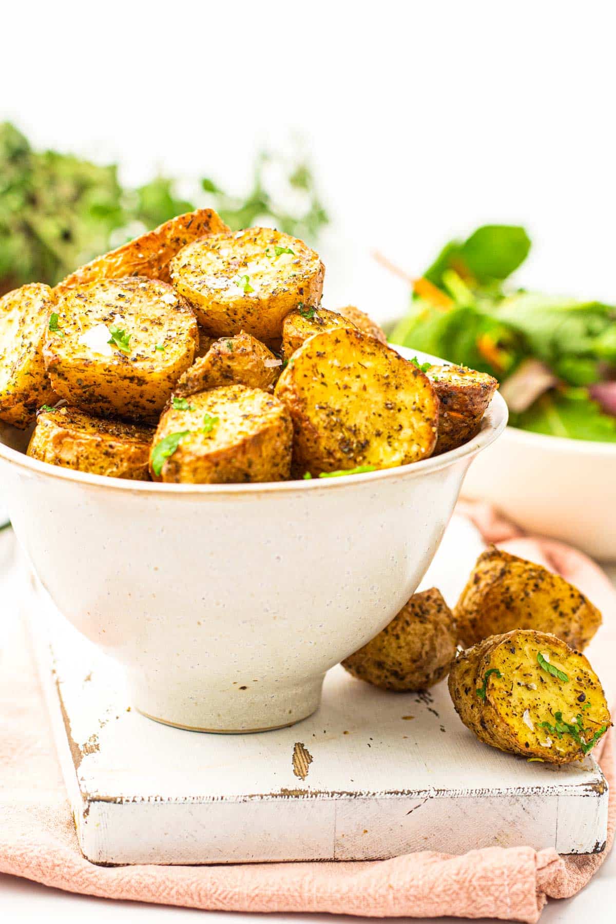 bowl full of chopped roasted potatoes covered in seasonings and parsley