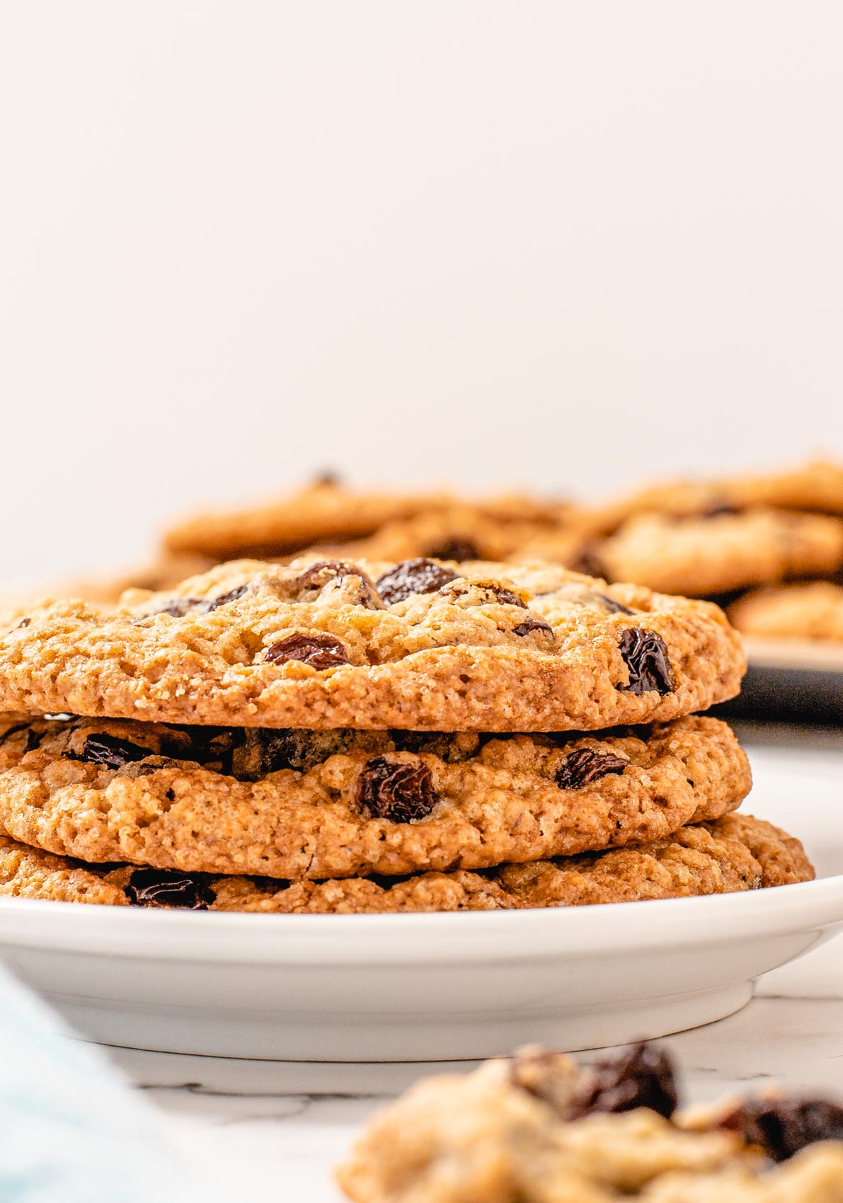 stack of three oatmeal raisin cookies on a white plate
