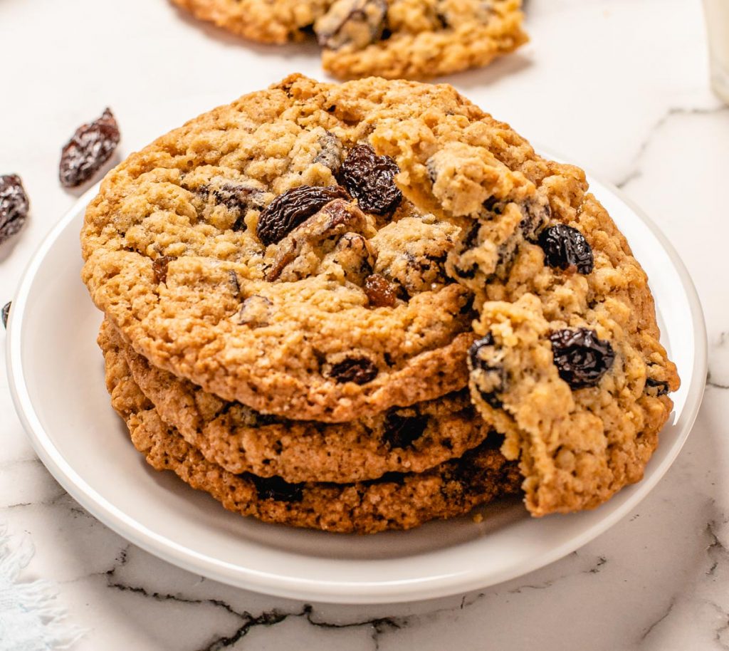 oatmeal raisin cookies stacked with one on top broken in half