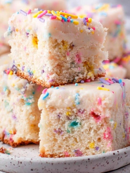 three pieces of funfetti cake with sprinkles stacked on top of one another