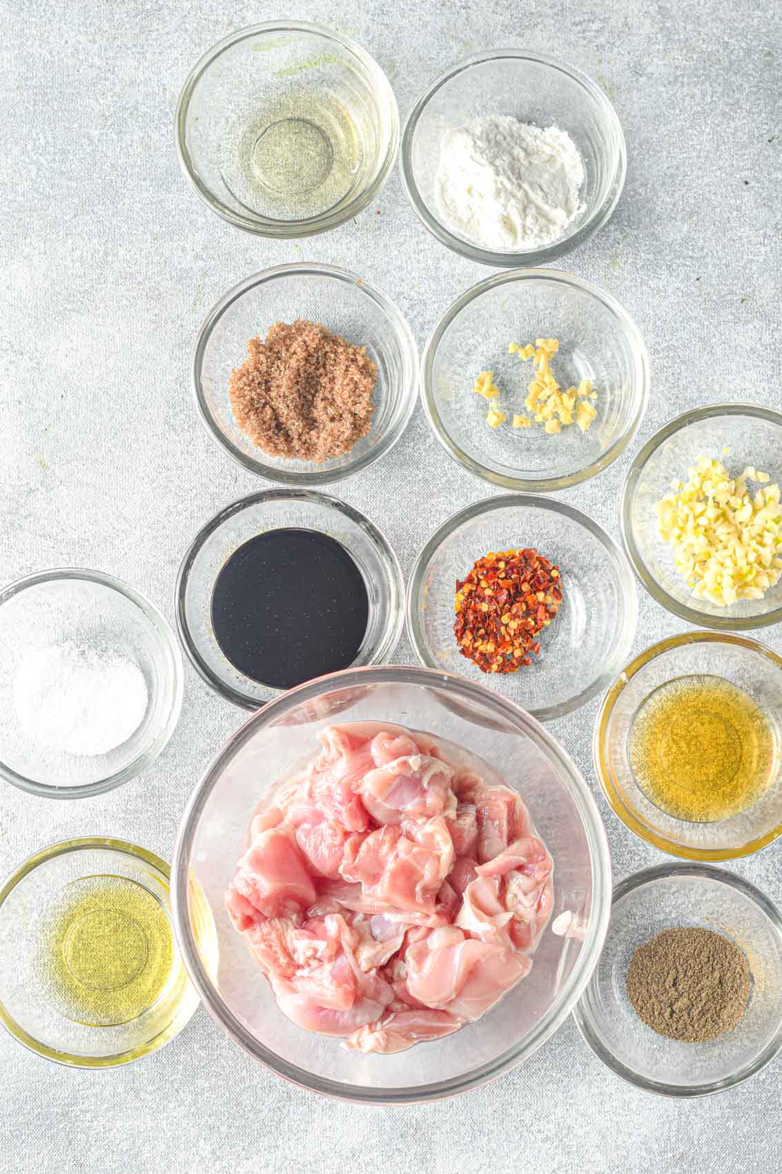 ingredients for chicken teriyaki, including sesame oil, garlic, ginger, soy sauce, red pepper flakes, and brown sugar