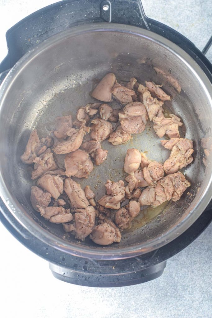 hot instant pot simmering with chicken bits