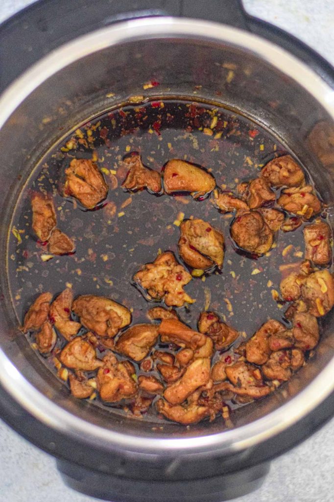 teriyaki sauce in an instant pot with bits of chicken