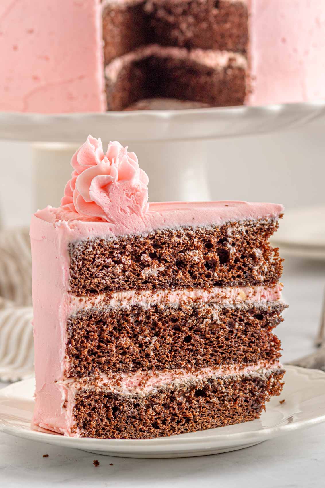 slice of thick triple layer kahlua cake with strawberry buttercream frosting