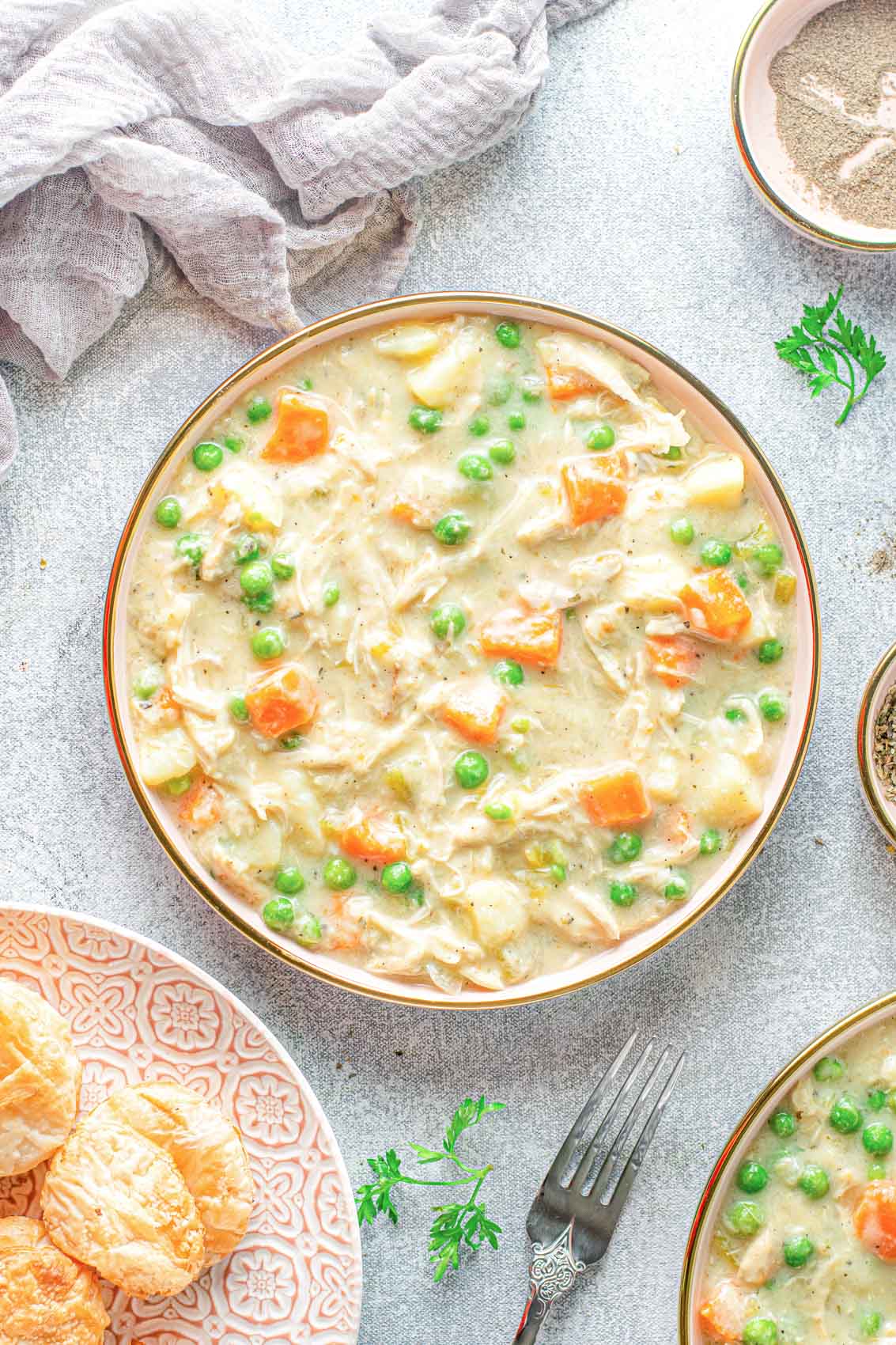 chicken pot pie soup in a bowl with biscuits and garnish