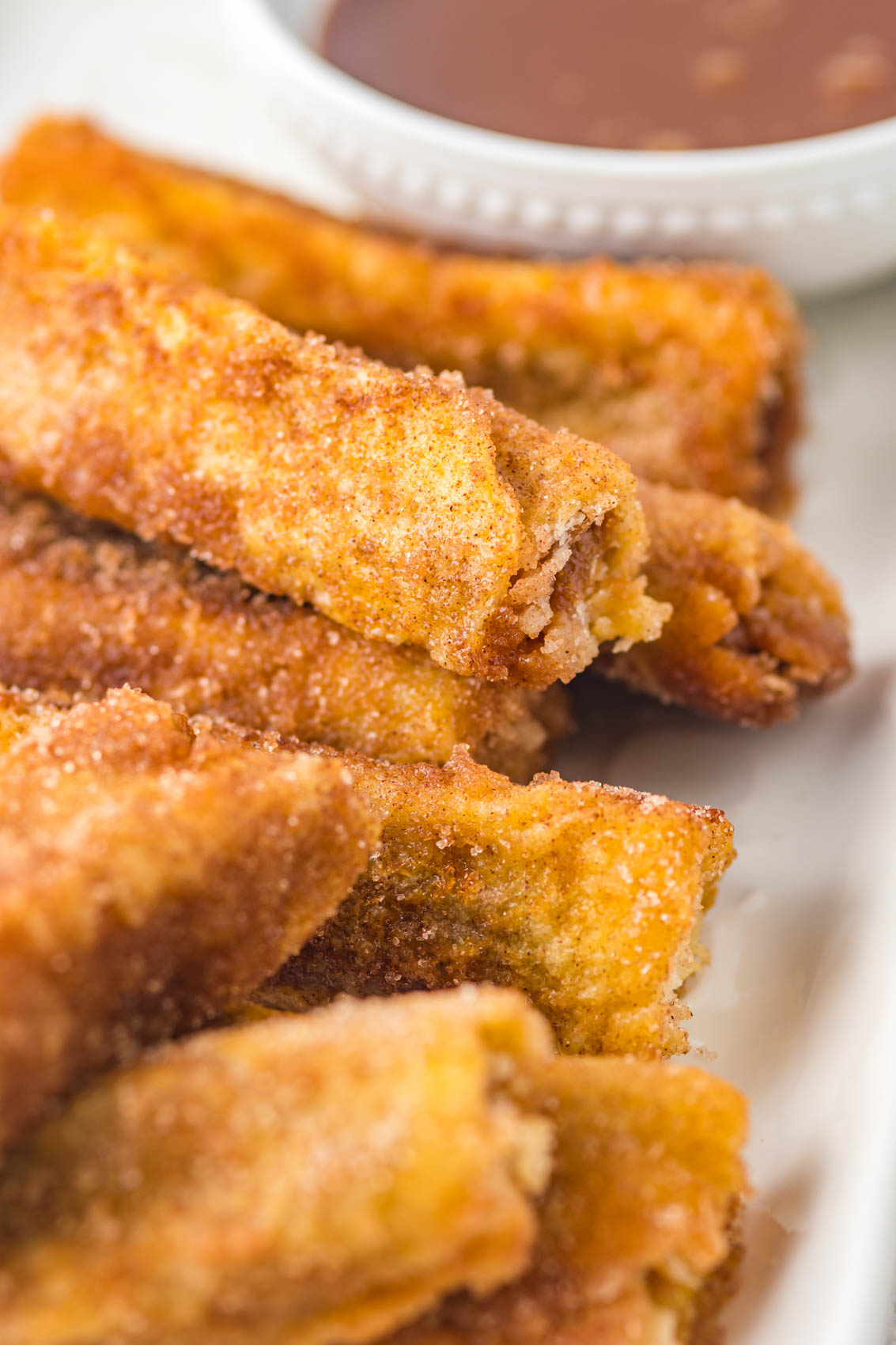 stack of churro french toast roll ups covered in cinnamon and sugar